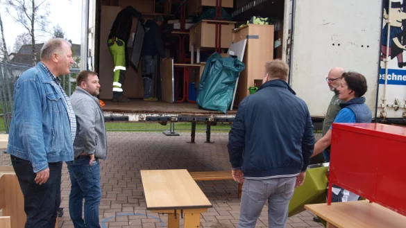 Stellvertretender B&uuml;rgermeister Willi D&uuml;wel (links) diskutiert mit freiwilligen Helfern dar&uuml;ber, wie St&uuml;hle, Tische, B&auml;nke aus Alverdissen zeitsparend zur Grundschule Barntrup transportiert werden k&ouml;nnen. - &copy; Hajo G&auml;rtner