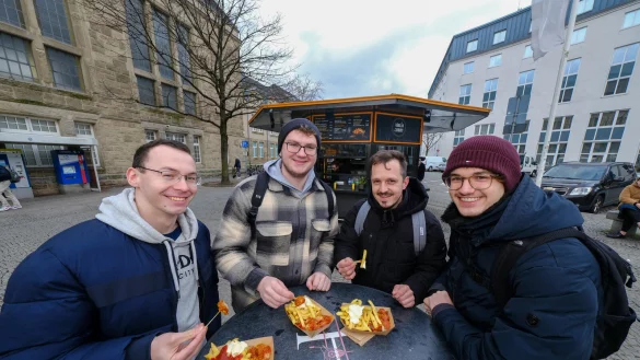 Vier Freunde vor der neuen Fritten-Bude am Hauptbahnhof (v.l.): Dennis, Jannis, Tobias und Moses testen Bärlin Curry. - © Andreas Zobe