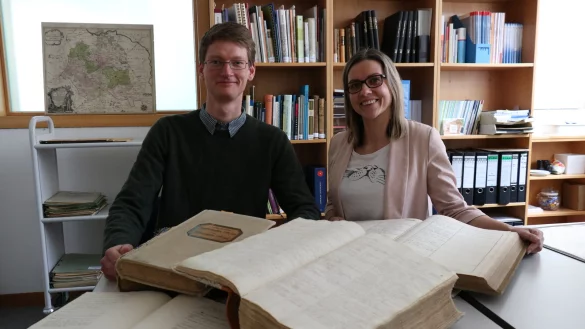 Die Archivare Katja Wiebe und Lars Sonnenberg mit einigen alten Kirchenb&uuml;chern und Dokumenten, die bei der Ahnenforschung helfen k&ouml;nnen. - &copy; Alexandra Schaller