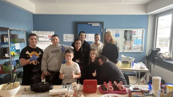 Kadir (von links), Seyyit (beide achte Klasse), Joel (fünfte Klasse), Zeinab, Lea, Nelly, Leonie, Jasmin und Leoni (alle zehnte Klasse) freuen sich, dass ihr Verkauf von Waffeln und weiteren Leckereien so erfolgreich gewesen ist. - © Sekundarschule Blomberg