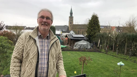 Joachim Licht steht in seinem Garten in Sch&ouml;tmar. In Hintergrund ist die Kilianskirche zu sehen. - &copy; Sven Kienscherf