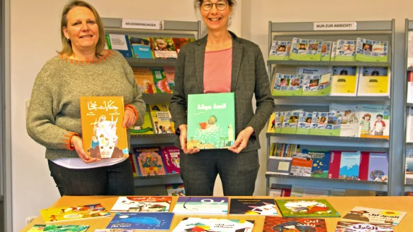Claudia Kloock (links) und Beate Becker pr&auml;sentieren die neuen arabischsprachigen Kinderb&uuml;cher in der MiKI. - &copy; Kreis Lippe