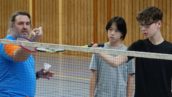 TV Lemgo-Trainer Oliver Beermann mit den beiden Jugendlichen Linus (14) und Yichu (13) am Netz - ein Stoppball will gelernt sein. - &copy; Axel B&uuml;rger