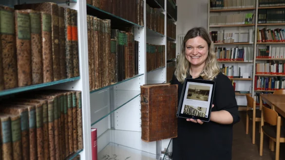 Sonja Beinlich mit einem alten Buch und einem modernen Tablet - sie leitet seit 1. April das Salzufler Stadtarchiv und hat viel vor. - &copy; Alexandra Schaller