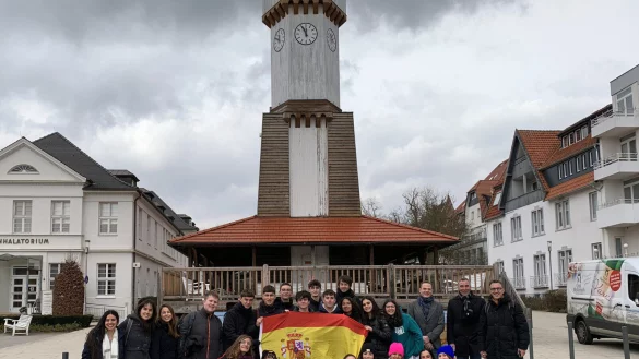 Bildunterschrift: Sch&uuml;lerinnen und Sch&uuml;ler aus Spanien, Lehrkr&auml;fte aus Spanien und Deutschland, sowie der Leiter der Gesamtschule Aspe Oliver Dudek (obere Reihe, 3. von rechts) und B&uuml;rgermeister Dirk Tolkemitt (obere Reihe, 2. von rechts) treffen sich zum gemeinsamen Austausch am Uhrenturm-Gradierwerk. - &copy; Stadt Bad Salzuflen