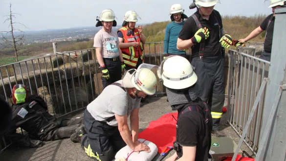 Die &Uuml;bung sieht eine versuchte Wiederbelebung auf dem Bismarckturm vor. R&uuml;diger B&ouml;ke (links) von der L&ouml;schgruppe W&uuml;sten gibt der Puppe eine Herzdruckmassage. Henri Br&uuml;ning (kniend rechts) steht zur Abl&ouml;sung bereit. - &copy; Daniel Hobein/Feuerwehr Bad Salzuflen