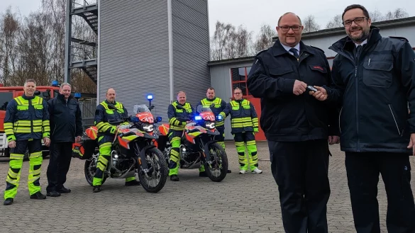In Lippe im Einsatz: Sascha Medina (vorne rechts) &uuml;bergibt Marco Gr&ouml;ne die Schl&uuml;ssel f&uuml;r die neuen Kr&auml;der. Kreisbrandmeister Wolfgang Kornegger (hinten, Zweiter von links) freut sich mit Detlef Limpke, Emil Hein, Mario Trompeter, Mike Bartels und Ingo B&uuml;schemann (von links), die k&uuml;nftig auf den Motorr&auml;dern unterwegs sein werden. - &copy; Kreis Lippe
