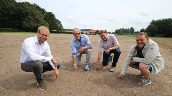 Passt der Boden? Das pr&uuml;fen (von links) B&uuml;rgermeister Borris Ortmeier, TBV-Jahn-Vorsitzender Thomas Schwekendiek, Landtagsabgeordneter J&uuml;rgen Berghahn und Vereinsmitglied Timo Konieczny und lassen sich vom Starkregen-Zwischenfall die gute Laune nicht verderben. - &copy; Jens Rademacher