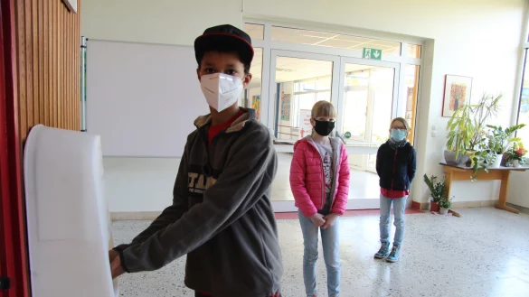 Jeremy desinfiziert sich die H&auml;nde, w&auml;hrend Wiktoria (links) und Helen warten, bis sie an der Reihe sind.&nbsp; - &copy; Kirsten Fuhrmann