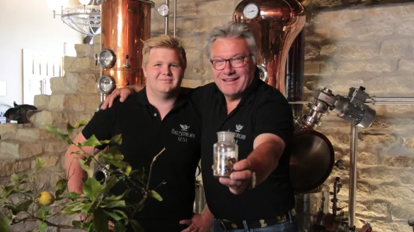 Falk und Friedhelm Begemann vor ihrer Destille. In den H&auml;nden halten sie ihre spezielle Gin-K&auml;uter-Mischung. Und auch die Zitronen f&uuml;r das Finish stammen aus eingenem Anbau. - &copy; Carolin Brokmann-F&ouml;rster