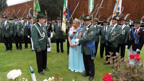 Königliche Pracht: Aufmarschoffizier Jürgen Schröder (links) überreicht den aktuellen Majestäten Sascha Ruge und Britta Ruge-Koring ein Schild, das künftig „ihre" Rose zieren wird. Mittlerweile ist es der fünfte Strauch, der seit 2009 von Salzufler Regenten als Erinnerung im  Rosengarten am Gradierwerk gepflanzt worden ist. - © Foto: Privat