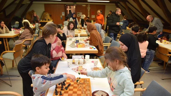 Die Familien nutzen das Spieleangebot im Saal des B&uuml;rgerhauses. Das reicht von Schach &uuml;ber Kartenspiele bis hin zu gro&szlig;en Holzspielen. Ehrenamtliche unterst&uuml;tzen und kommen mit den Gefl&uuml;chteten ins Gespr&auml;ch. Foto: Karin Prignitz - &copy; Karin Prignitz