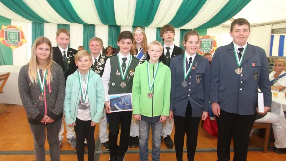 Stolze Preisträger: (von rechts) Dustin Arbschat, Lena Levien-Schröder, Cedrik Hartz, Finn Requardt,  Lynia Hartz und Josefine Stumpenhagen haben beim Jugendpreisschießen gesiegt. Hinten stehen unter anderem Jugendkönig Felix Johann auf der Heide und Königin Jacqueline Plöger. - © Daniel Hobein