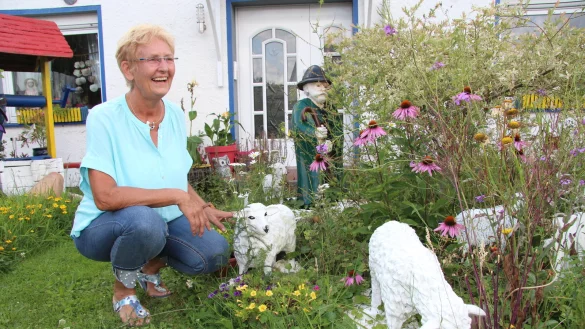 Carola Pla&szlig; sitzt &bdquo;bei ihren Sch&auml;fchen&ldquo; im Garten. Dort gibt es noch viele weitere Figuren zu sehen, teilweise hat sie diese sogar selbst gestaltet. - &copy; Nadine Uphoff