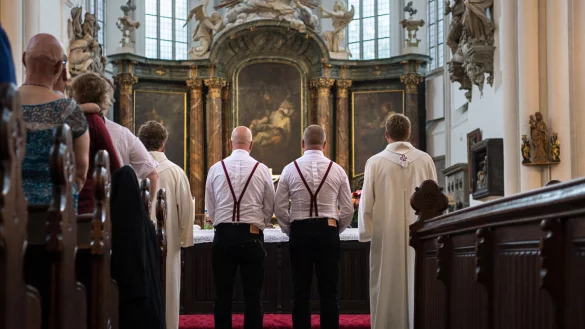 Zwei homosexuelle M&auml;nner stehen bei ihrer Trauung in der Berliner Marienkirche mit zwei Pfarrern vor dem Altar. F&uuml;r immer mehr homosexuelle Paare erf&uuml;llt sich der Wunsch nach einer kirchlichen Trauung. Auch die Lippische Landeskirche schafft nun diese M&ouml;glichkeit. - &copy; Wolfram Kastl/dpa