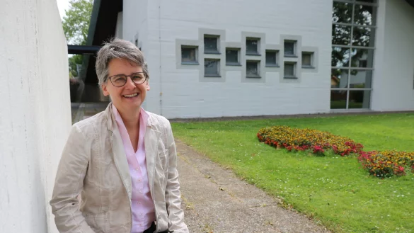 Jutta Schlitzberger sitzt an der Lockhauser Christuskirche. Der Fisch aus Blumen ist in der Corona-Zeit entstanden. - &copy; Alexandra Schaller