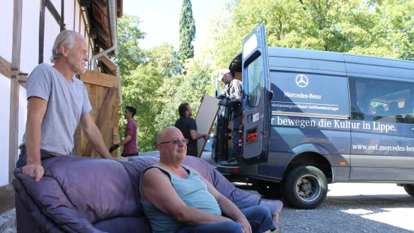 Projektleiter Jürgen Linnemann (links) und Lothar Werner, der ein gebrauchtes Sofa testet. Alexej Esau lädt gerade auf (hinten). - © Eva-Maria Morenz