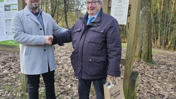 Lucas Noke, Leiter des Tourismus-Büros der Stadt Lage, bedankt sich bei Bernd Rosarius. Der hat die Autorengruppe "Garten der Poesie" gegründet und gibt seit Jahrzehnten Autorinnen und Autoren ein Forum. Am Wanderweg in Hörste stehen zum Beispiel Gedichte. - © Astrid Sewing