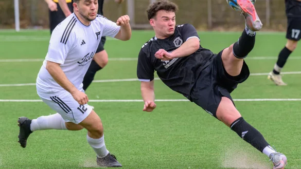 Gekonnt geklärt: Akrobatisch klärt der Pivitsheider Jannis Römisch (schwarz) vor dem heraneilenden Horner Volkan Coban. - © Egon Penner