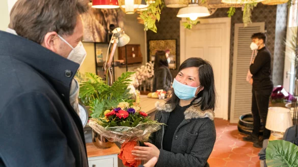 Ladeninhaberin Hien Mai erh&auml;lt Blumen zur Er&ouml;ffnung ihres Gesch&auml;ftes f&uuml;r Wohnaccessoires und Einrichtungsgegenst&auml;nde. - &copy; Torben Gocke