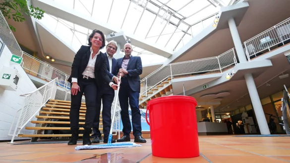 Es regnet durch: Eva Ellminger, J&ouml;rg Karlikowski und Stefan Freitag greifen hier symbolisch zum Aufnehmer der an regnerischen Tagen aber tats&auml;chlich an mehreren Stellen im Geb&auml;ude zum Einsatz kommt. Und statt der gro&szlig;z&uuml;gigen Eingangshalle im Stil der 80er Jahre br&auml;chten die Stadtwerke heute eher mehr B&uuml;ro- und Besprechungsr&auml;ume. - &copy; Jost Wolf