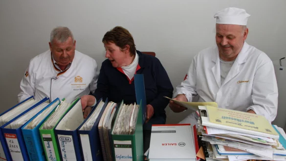 Bürokratie ist ihr Leben, aber eigentlich sind es doch Brötchen und Wurst: Kreishandwerksmeister Mickel Biere (links) sowie Alexandra und Andreas Grämmel wälzen Akten. - © Martin Hostert