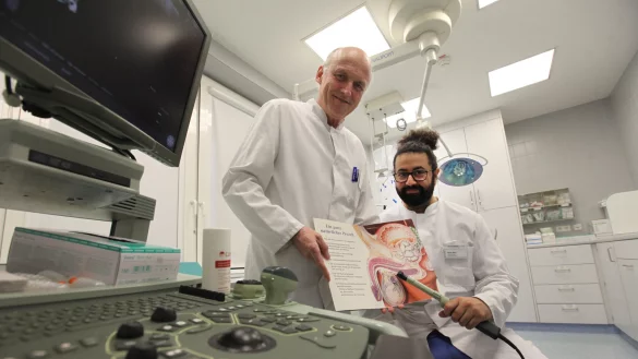 Dr. Alfons Gunnemann und Hares Alam demonstrieren anhand einer Grafik, wie das vonstatten geht. Der Check sei unkompliziert, sagen die Mediziner. - © Vera Gerstendorf-Welle