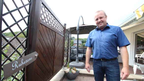 Mario Hecker auf der Terrasse seines Hauses in Bavenhausen. Ein Schild weist auf die &bdquo;Ruhezone" im Hintergrund. Dort legt der 45-J&auml;hrige auch mal die F&uuml;&szlig;e hoch.&nbsp; - &copy; Jens Rademacher