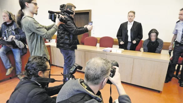 Großes Medieninteresse: Dieter O. sitzt zwischen seinem Verteidiger Carsten Ernst und dem Justizangestellten Reinhard Kleesiek. Fotografen und Kameramänner lichten den 22 Jahre alten Mann aus Oerlinghausen ab. - © Gunter Held
