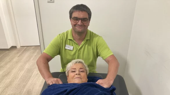 Stellvertretender Therapieleiter Thiemo Radke wickelt Annemarie Reuter aus ihrer Moor-Packung, die ihr sehr gut getan hat. - &copy; Cordula Gr&ouml;ne