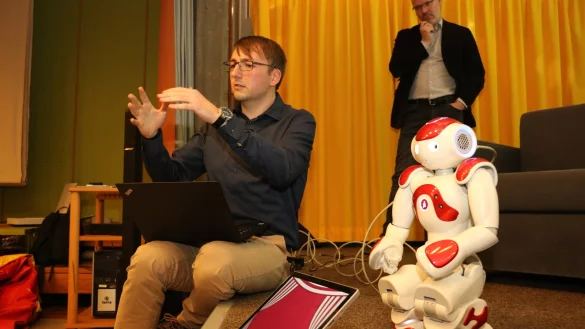 Arbeiten gemeinsam mit Robin: Doktorand Thorsten Schodde (links) und Prof. Dr. Stefan Kopp erklären vor dem Verein für Schulpsychologie das Einsatzgebiet der menschenähnlichen Maschine. - © Guntmar Wolff