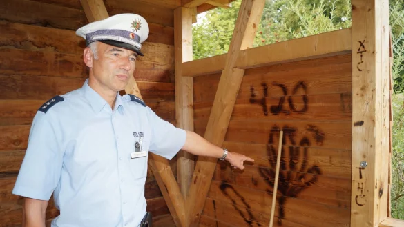 Am Tatort: Frank Marohn zeigt die Besch&auml;digungen, die Unbekannte mit einem Gasbrenner im Holz der Schutzh&uuml;tte im &bdquo;Paradies" verursacht haben. Der Bezirksbeamte hat hier oft mit Konflikten insbesondere mit und unter Jugendlichen zu tun. - &copy; Jan Christian Pinsch