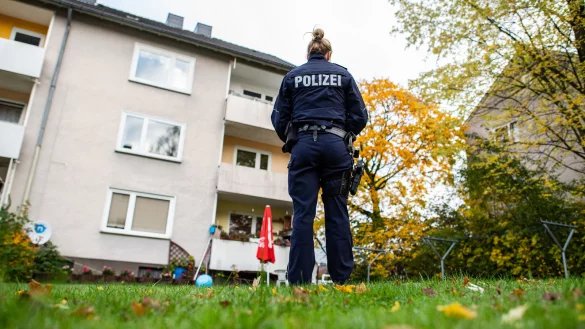 Eine Polizistin steht im Garten des Mehrfamilienhauses, wo eine 15-J&auml;hrige ihren dreij&auml;hrigen Halbbruder mit einem Messer get&ouml;tet haben soll. - &copy; dpa