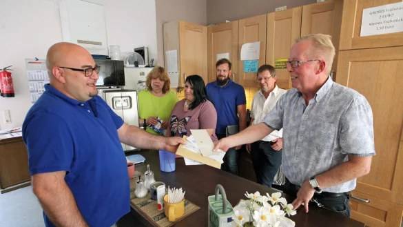 Mathias M&uuml;ller (links) holt sich bei Sozialarbeiter Volker Hansmann im Caf&eacute; der Herberge zur Heimat seine Post ab. Im Hintergrund (von links): Heike Lux und Melanie Schabaker, die an diesem Tag Thekendienst im Begegnungscaf&eacute; machen, Streetworker Willi Dick und der Leiter der Herberge zur Heimat, Matthias Neuper. - &copy; Bernhard Preu&szlig;
