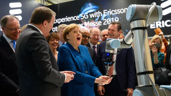 Zum Auftakt der&nbsp;Hannover&nbsp;Messe&nbsp;geht Bundeskanzlerin Angela Merkel &uuml;ber das Messegel&auml;nde und betrachtet am Stand des schwedischen Unternehmens Ericsson einen Roboter.&nbsp; - &copy; Christophe Gateau/dpa