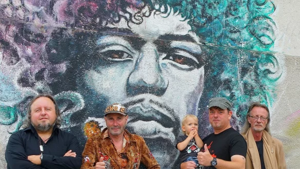 Das Adagio-Komitee: (von links) Chorleiter Norbert G&ouml;rder, Dr. Joachim Dewe (Leiter der Rockakademie OWL in Herford), S&auml;nger Thomas  W&ouml;hler mit Sohn und Musiker Michael Schulte stehen vor einem Bild von Jimi Hendrix. - &copy; Andreas Leber