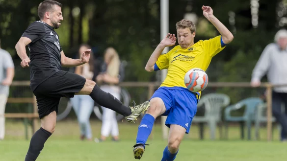 Volleyschuss: Im letzten Moment versucht der L&uuml;gder Yannick Pape (gelb) den Distanzschu&szlig; von Henning Diekmann (links, schwarz) abzublocken. Der Schu&szlig; verfehlt allerdings sein Ziel. - &copy; Egon Penner