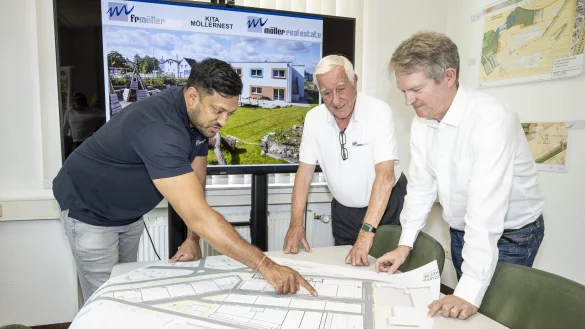 Projektleiter Manusch Varatharajah, Senior-Chef Peter von Möller und Möller-Real-Estate-Geschäftsführer Dennis Rauhut (v. l.) beugen sich über die Baupläne. - © Jörg Dieckmann