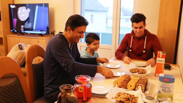 Frühstück mit dem Nachwuchs: Vater Afeez L. aus Afghanistan mit seinem neunjährigen Sohn. Dolmetscher Ikratullah Danial (rechts) ist ebenfalls dabei. - © Alina Hetland