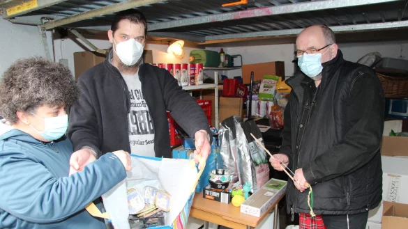 Hilfe aus der vollen Garage: &bdquo;Mister Tiertafel" Uwe vom Lehn (rechts) gibt Katzenfutter an Kerstin Karbach und J&ouml;rg R&auml;ger aus.&nbsp; - &copy; Silke Buhrmester