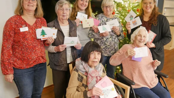 Ein weihnachtlicher Gruß für jeden: Die Bewohnerinnen freuen sich mit Hausleitung Sarah Köpel (rechts) und Melanie Beuke vom Begleitenden Dienst (links) über die viele Weihnachtspost der Schülerinnen und Schüler, die Lehrerin Nicole Burgard (hinten, Mitte) vorbeigebracht hat. - © Fotorechte: Diakonis