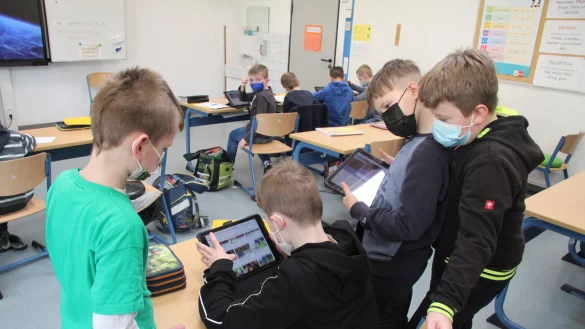 Bei der Suche nach Inhalten f&uuml;r ihr digitales Plakat unterst&uuml;tzen sich die Drittkl&auml;ssler gegenseitig. Ihre Arbeitsergebnisse k&ouml;nnen sie auch auf den gro&szlig;en Touchscreen beamen. - &copy; Dieter Asbrock