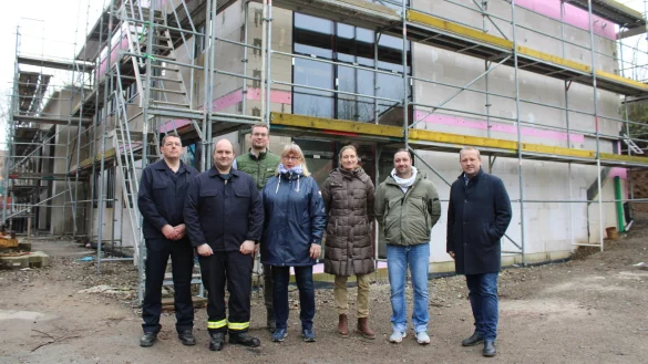 Michael Little (stv. Leiter Feuerwehr Kalletal, von links), Andreas Wagner (Löschgruppenführer Talle), Simon Prüßner (SPD-Ratsmitglied), Brigitte Lähnemann (UKB-Ratsmitglied), Architektin Wera Binder, Nikolai Stoll (Fachbereich Planen und Bauen) und Bürgermeister Mario Hecker vor dem Neubau des Feuerwehrgerätehauses in Talle. - © Lorraine Brinkmann