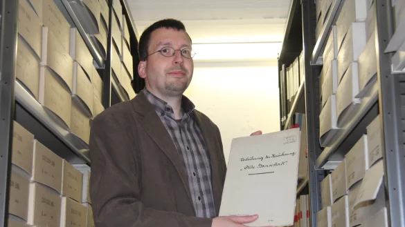 Blick in die Geschichte: Marcel Oeben, Leiter des Stadtarchivs Lemgo, zeigt im Magazin einen Ordner mit historischen Unterlagen zur Namensverleihung &bdquo;Alte Hansestadt" vor 100 Jahren. - &copy; Tobias Schneider