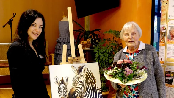 Vorstand Christina Dolls (li.) bedankte sich mit einem Blumenstrau&szlig; bei Waltraud Brandt (re.). Im Bild auch zu sehen ist eines ihrer Exponate. - &copy; Stift zu W&uuml;sten