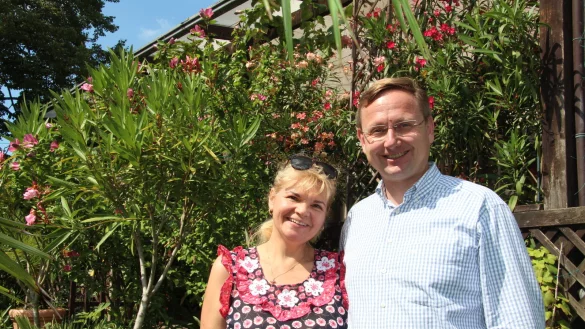 Andreas Wulf steht mit seiner Frau Lolita im Garten vor der Terrasse, an der der Oleander bl&uuml;ht. Die Zucht der Pflanzen sowie die Gartenarbeit geh&ouml;ren zu seinen Hobbys. - &copy; Nadine Uphoff