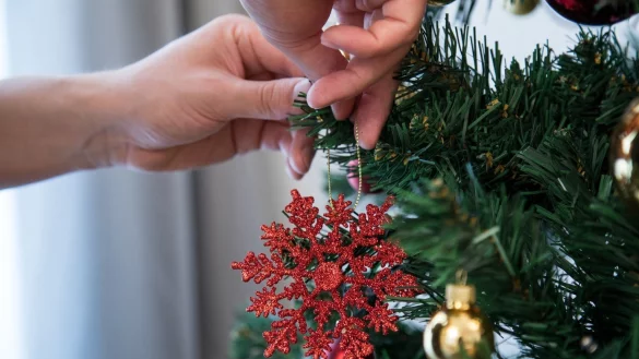 Ein Weihnachtsbaum wird geschm&uuml;ckt - &copy; Foto: Christin Klose/dpa-tmn