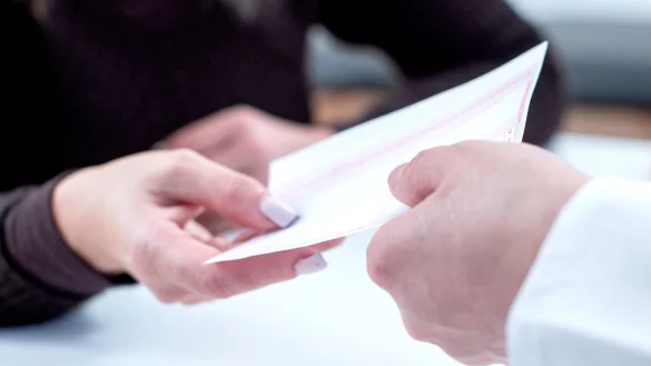 Eine Frau mit einem Rezept in der Apotheke - &copy; Foto: Christin Klose/dpa-tmn