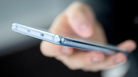 Ein Handy liegt in einer Hand - &copy; Foto: Andrea Warnecke/dpa-tmn