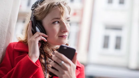 Eine Frau h&ouml;rt Musik mit einem Kopfh&ouml;rer - &copy; Foto: Christin Klose/dpa-tmn